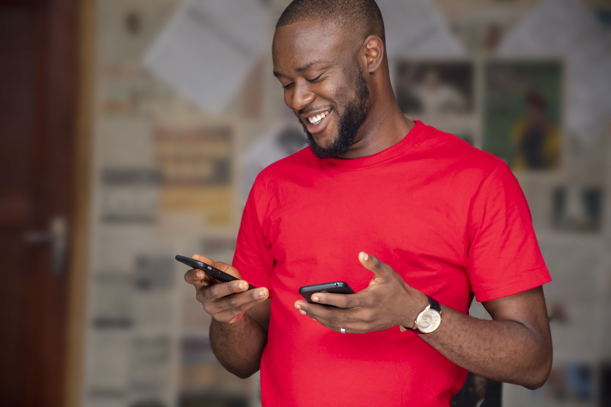 A man smiling after completing a transaction with his mobile phone